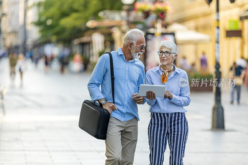 在市中心散步的高级商务夫妇