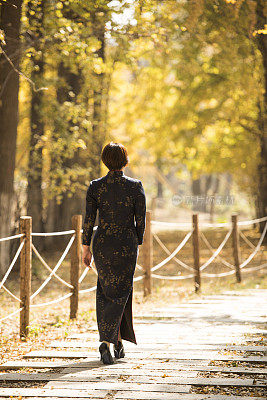 秋天走在树林里的中国妇女穿着传统的中国服装