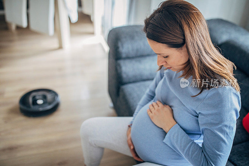 孕妇休息时，机器人真空吸尘器打扫地板