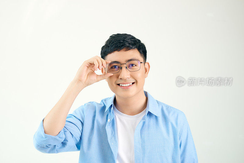 一个戴眼镜的朋友的特写。年轻的亚洲人调整眼镜，盯着镜头。视力和眼部护理理念