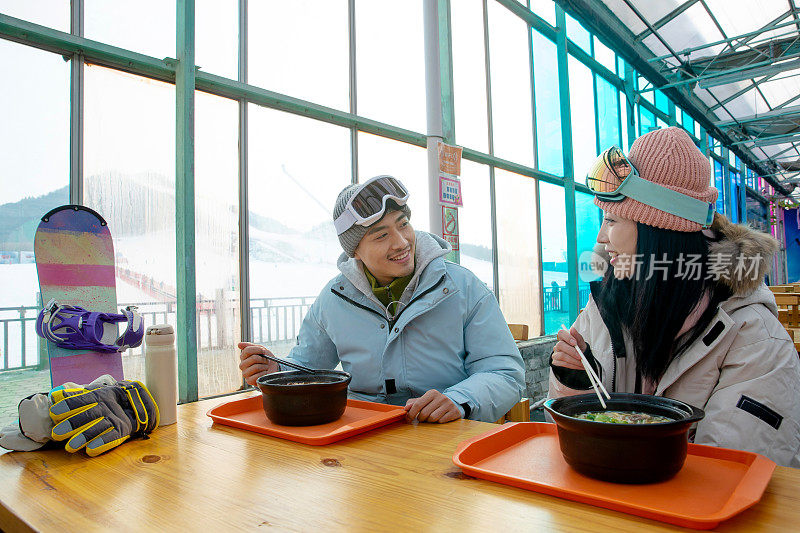 滑雪完的青年伴侣在餐厅用餐
