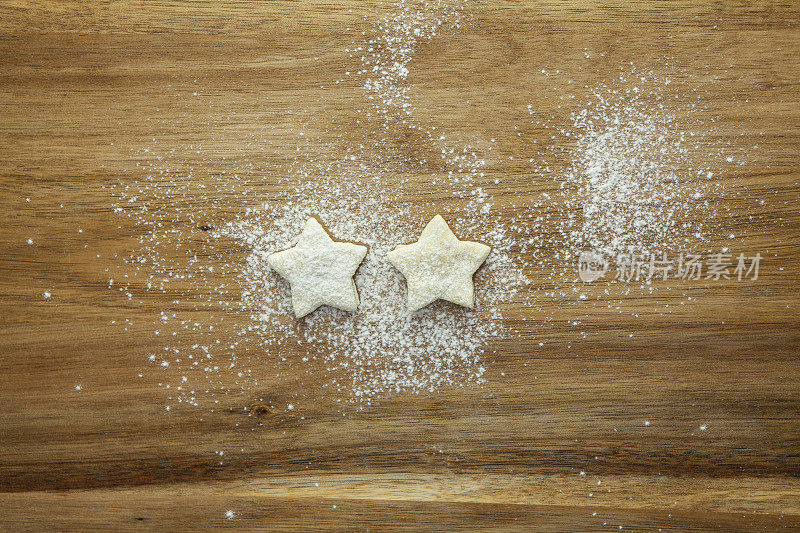 2星评级-由糕点星和在木质表面中间的糖霜表示