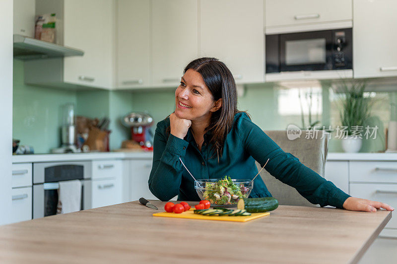 成年妇女在家庭厨房里准备健康食物