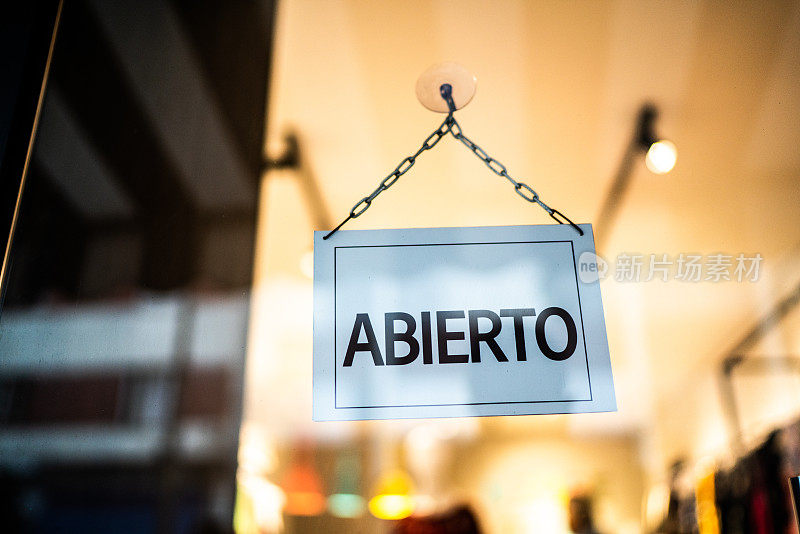 从商店的玻璃门可以看到打开的标识(abierto)