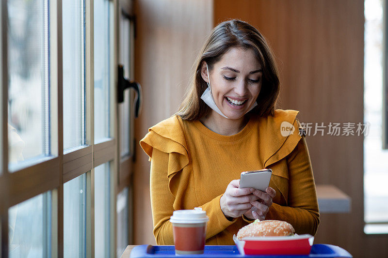 微笑的年轻女子正在给朋友发照片信息。