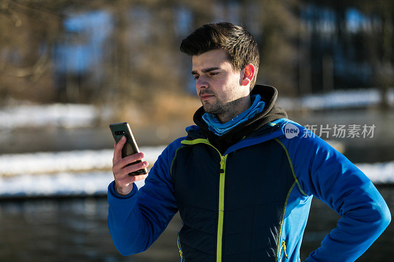男人站在湖边发短信时很生气。