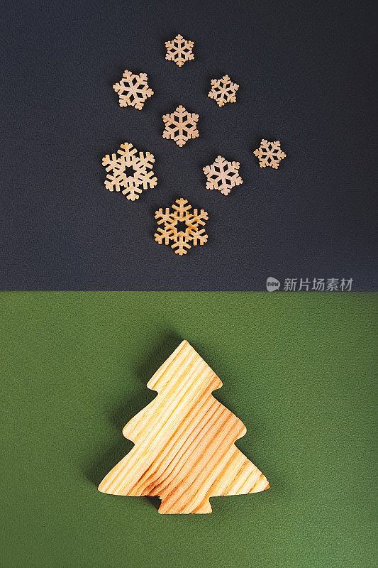 “零浪费”的新年理念是一棵木质的冷杉树和飘落的木质雪花在灰色和绿色的背景上。