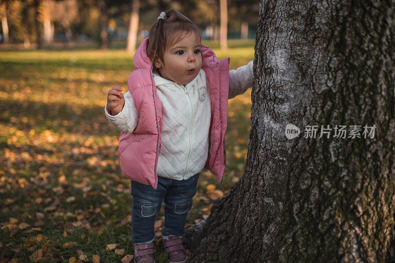一个一岁的小女孩在阳光明媚的日子里在公园里散步