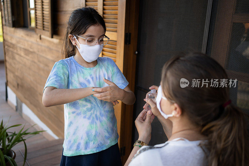 2019冠状病毒病期间母女佩戴防护口罩准备上学。新常态