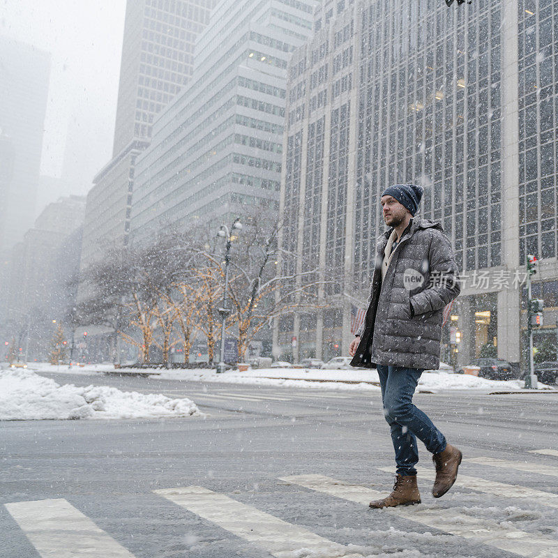 一个年轻人在一场大雪中穿过曼哈顿的街道