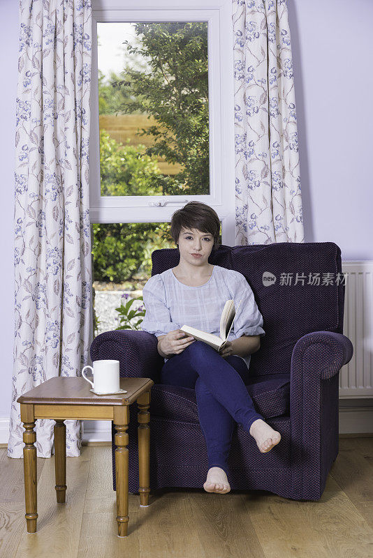 一个二十多岁的女人在家里悠闲地看书