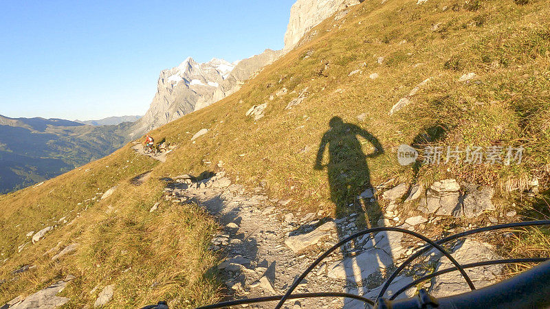 山地自行车手沿着瑞士阿尔卑斯山的小道骑行