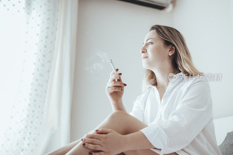 一个抑郁的女人在床上抽烟。