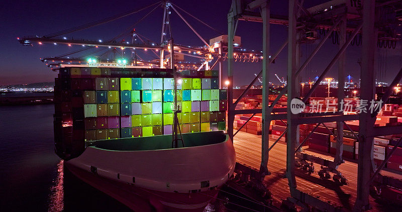 长滩港夜间载货船舶和灯火通明的集装箱堆场