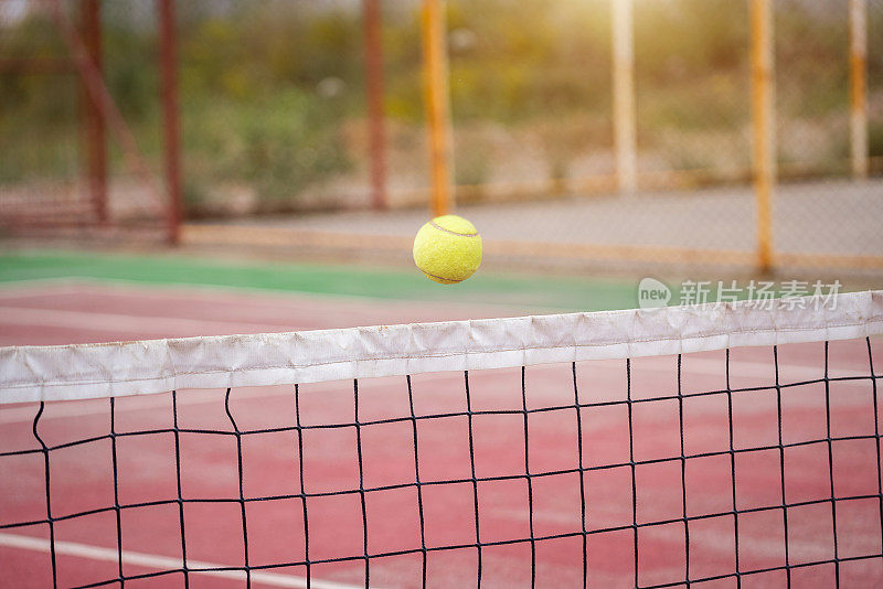 在网球场用球拍打网球。