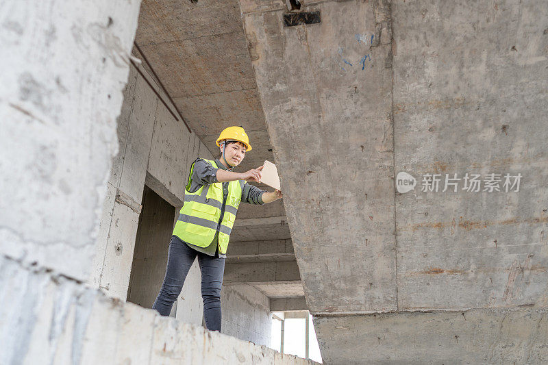 一位女建筑工程师正在用平板电脑拍照，以获取信息