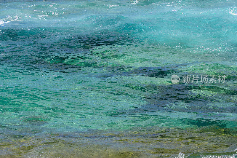 清澈的海水和顶部有波浪气泡的海浪