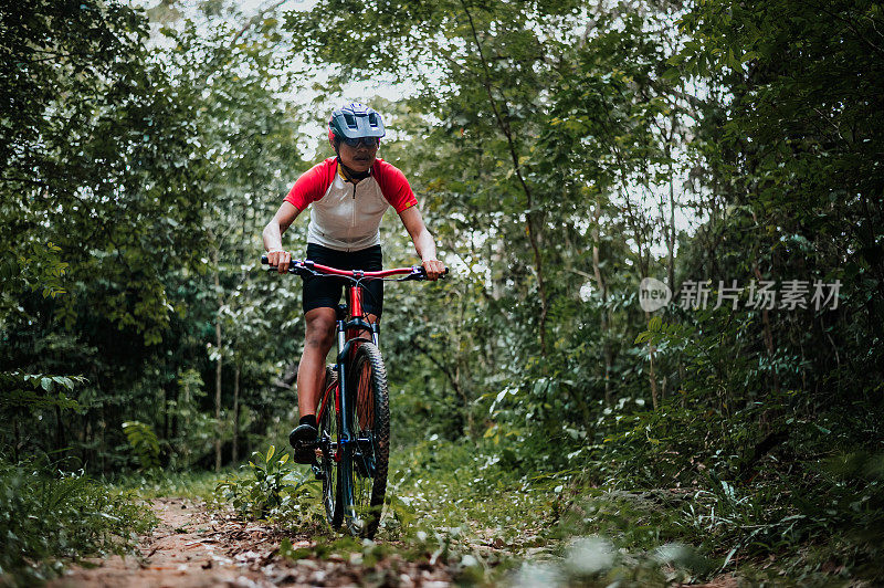 山地车骑行MTB，山地车下坡到达极限。一名亚洲男子骑着山地车在野外极限下坡。极限运动和MTB，山地自行车下坡概念。