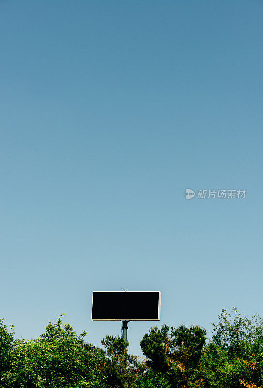 一个空的空白广告牌在蓝天下的垂直镜头