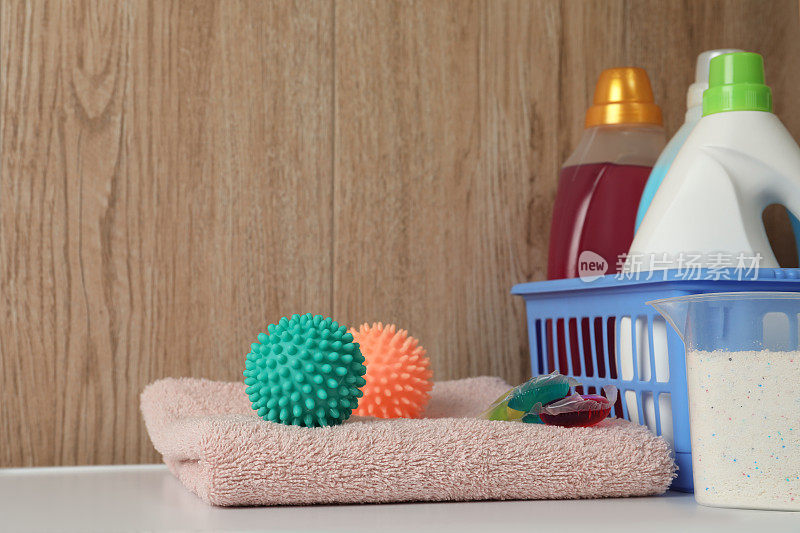 洗衣机上的干衣球、清洁剂和干净毛巾。文本空间