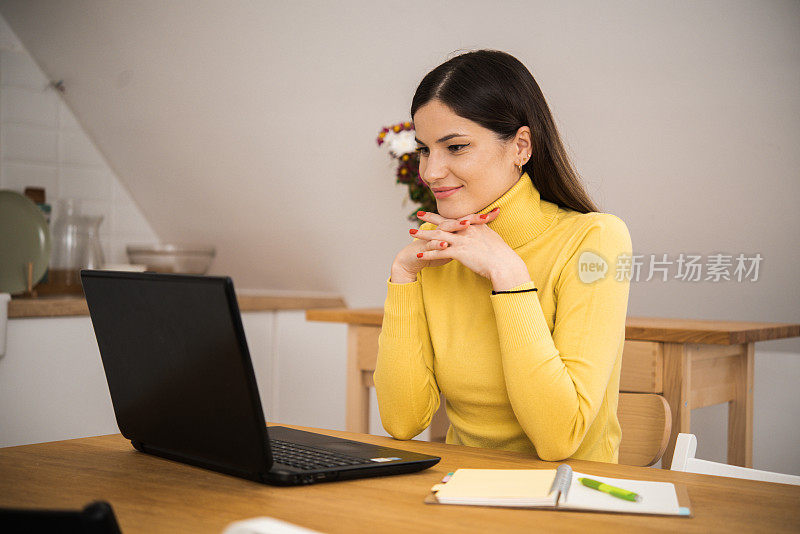 一个快乐的年轻女子在网上工作时享受咖啡的肖像