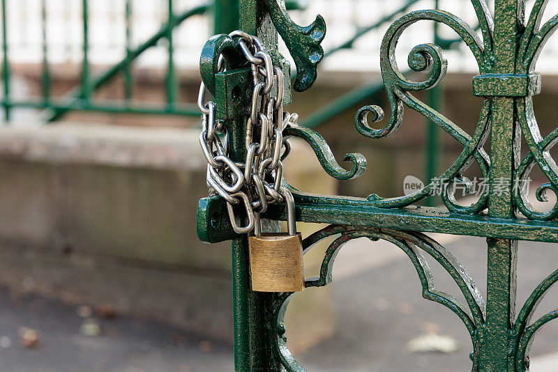 铁链和挂锁锁在一扇敞开的绿色大门上