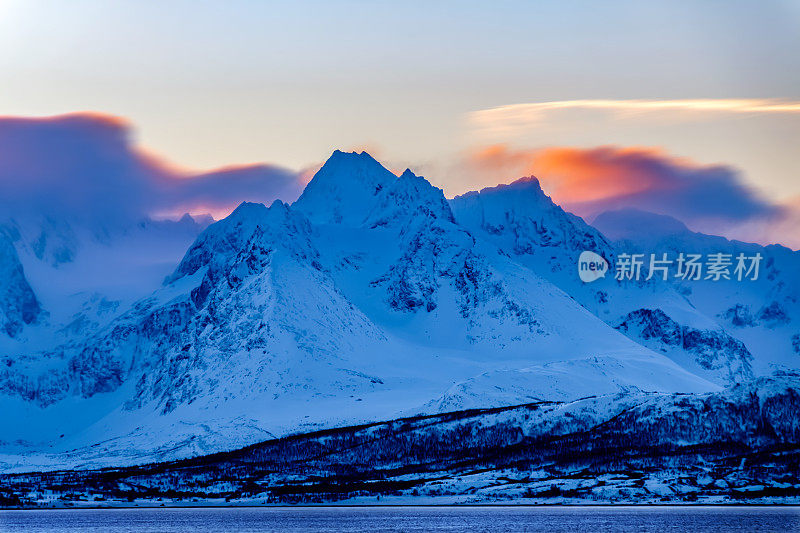 在白雪皑皑的挪威山脉，蓝色的冬日日出