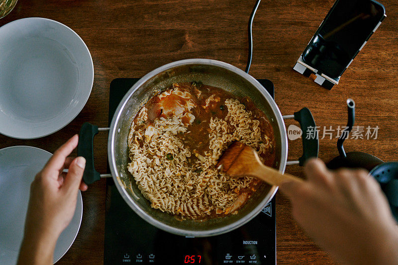 一个男人一边做饭一边上网看教程