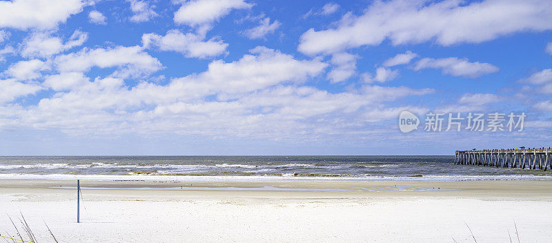 美国北佛罗里达州杰克逊维尔JAX海滩钓鱼码头附近的海景，白色泡沫波浪在白色沙滩上翻滚