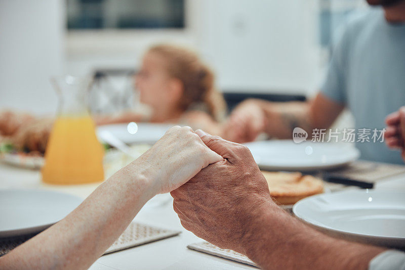 一家人，手牵着手，在家里的餐桌上为午餐祈祷。在吃饭、早午餐或自助餐前，感恩、信仰和祈祷、崇拜或感恩父母、祖父母和孩子。
