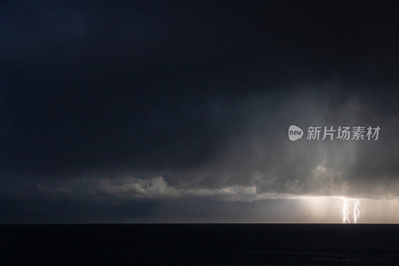 海洋上空的极端风暴伴随着降雨，闪电和黑暗的天空，云层