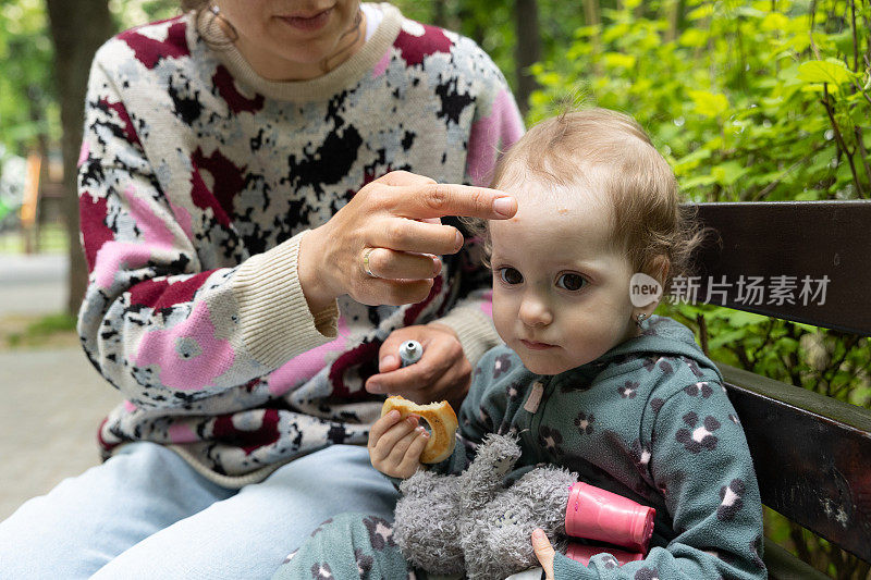 妈妈在公园里照顾她的孩子。