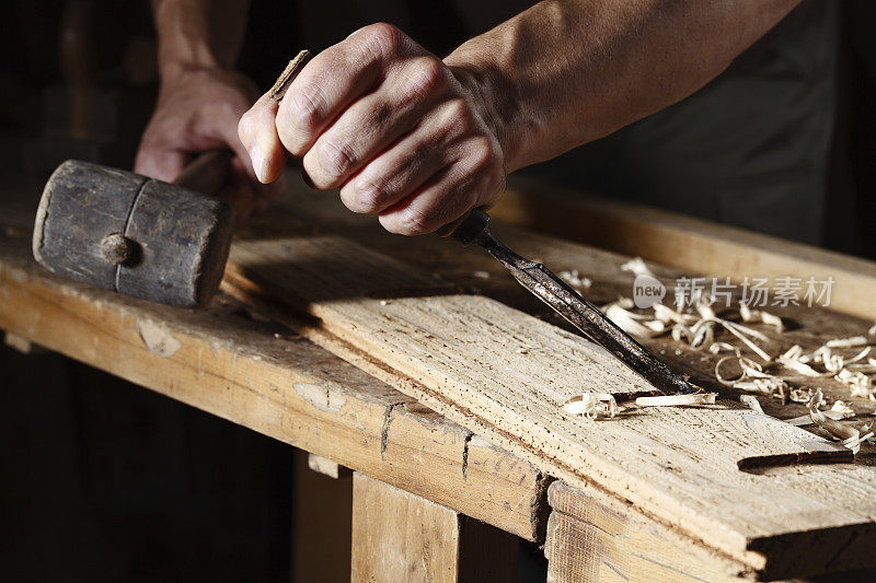 木匠用凿子和锤子工作的手