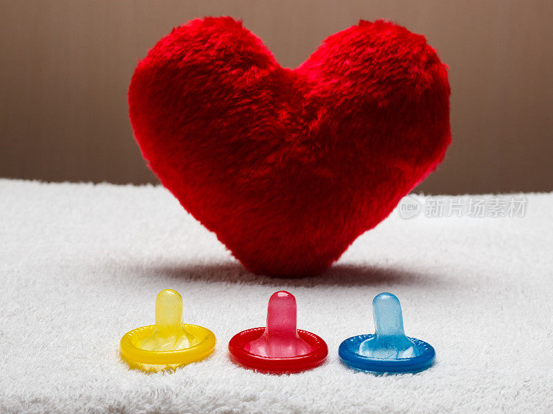 五颜六色的避孕套和红色的心