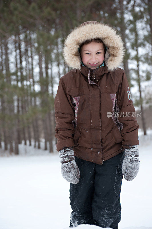 小女孩站在外面的雪地里