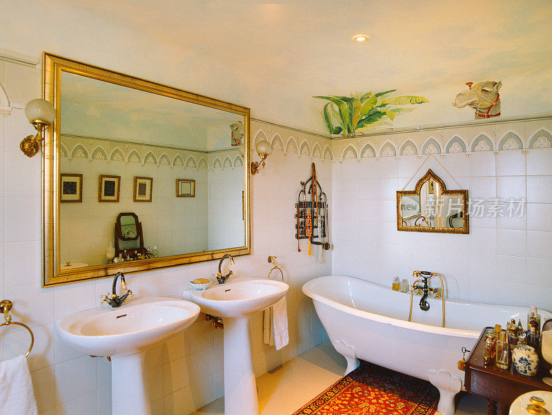 优雅的浴室:两个水槽，老式浴缸，金色装饰，壁画，地毯