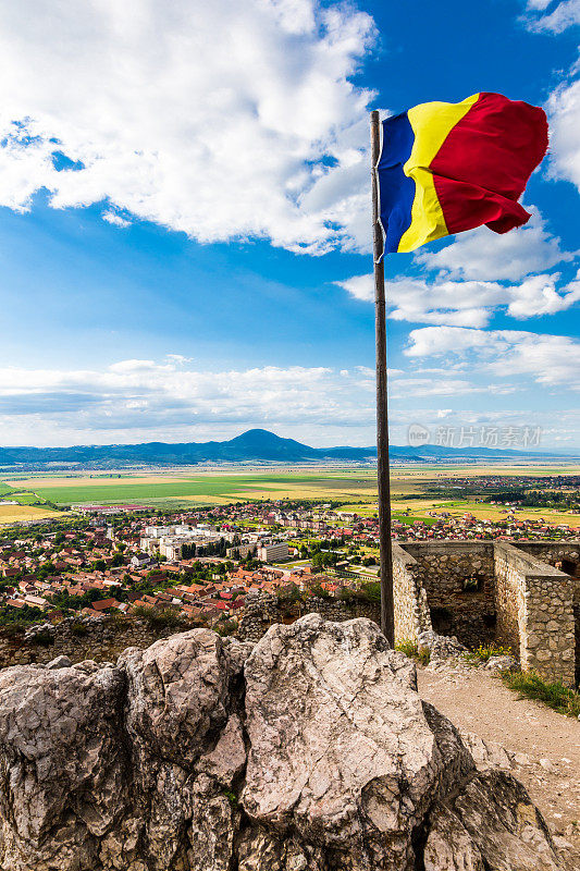 罗马尼亚国旗飘扬，下面是壮观的特兰西瓦尼亚风景