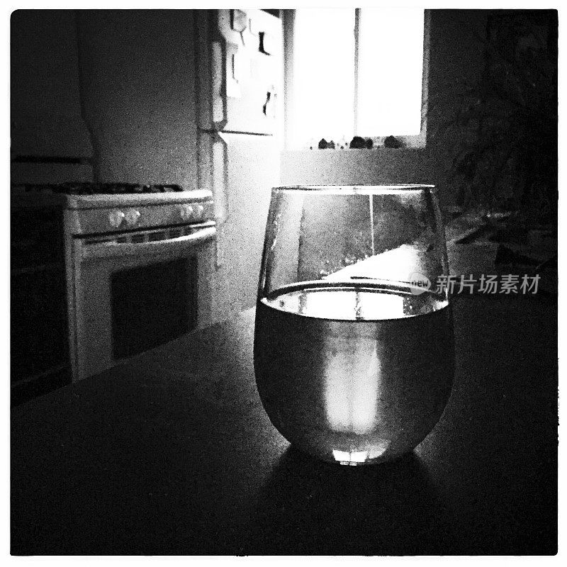 厨房柜台上的一杯葡萄酒