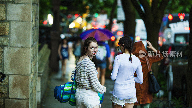 两个十几岁的女孩下雨天在曼哈顿大街上散步