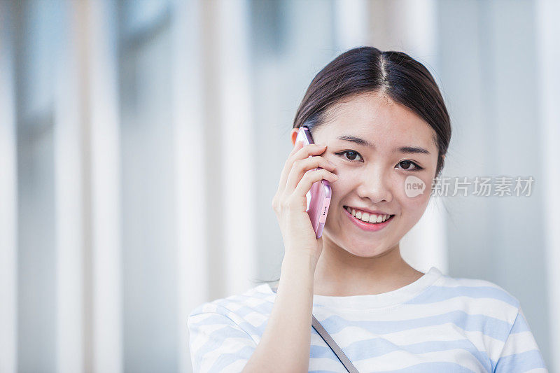 美丽的中国年轻女子正在用手机聊天