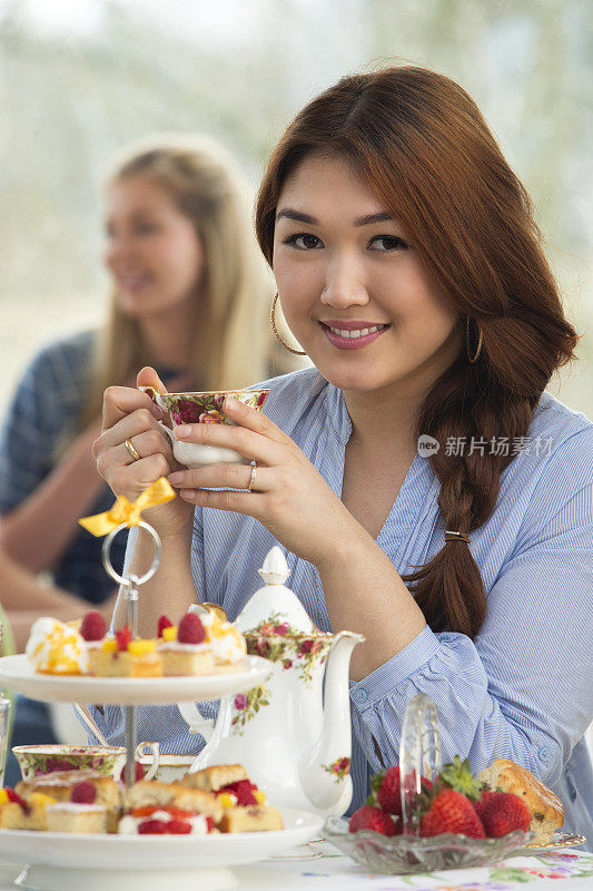 年轻的亚洲女人正在喝下午茶