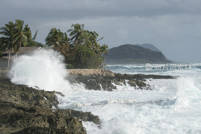 海浪冲击着夏威夷海岸线后面的山脉