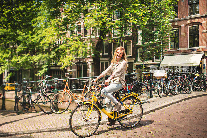 女游客在阿姆斯特丹骑自行车