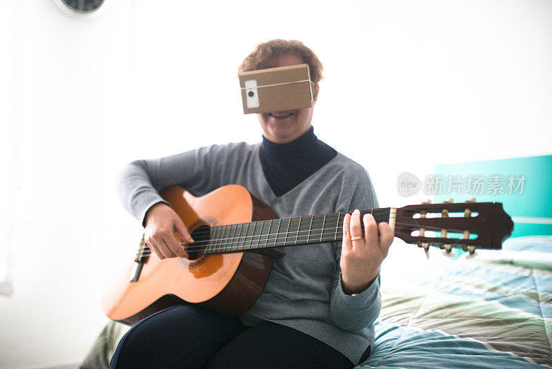 一个拿着吉他看虚拟现实设备模拟器的女人