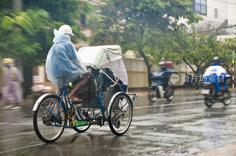 在越南芽庄，黄包车司机在雨中行驶
