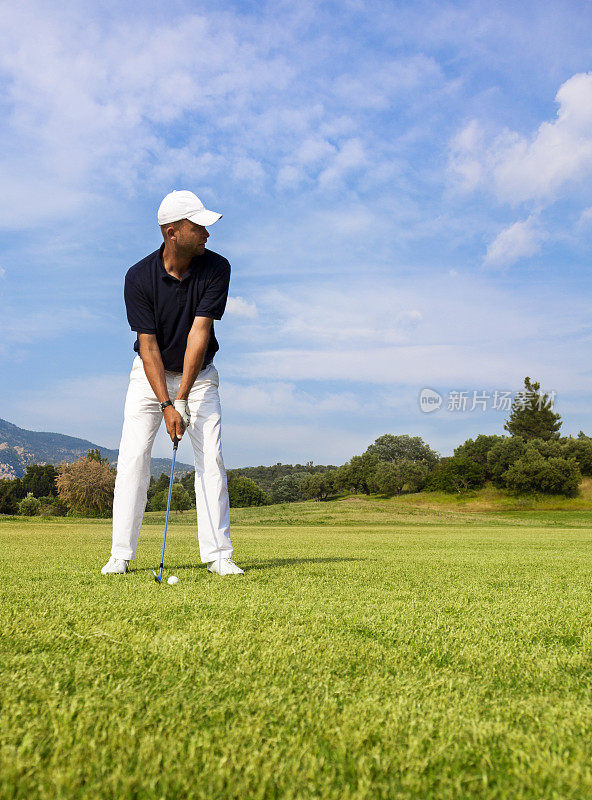 高尔夫球手准备击球。