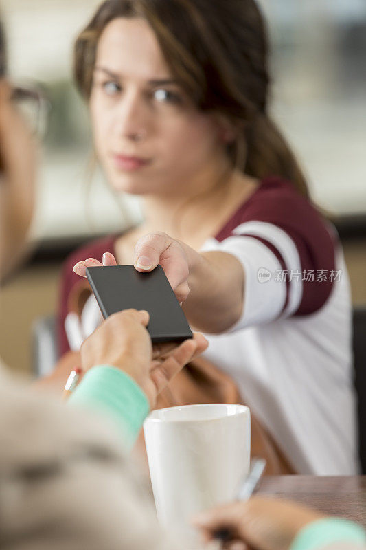 一个十几岁的女孩把电话交给校长的特写