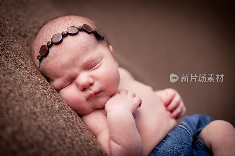 宝贝新生女婴戴着头巾，睡得很安稳