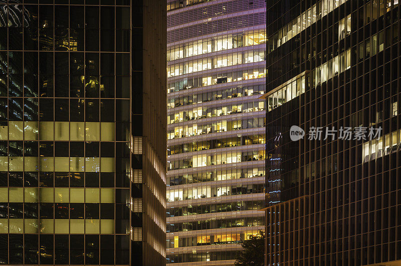 拥挤的办公大楼在夜晚照亮了新加坡市中心摩天大楼的窗户