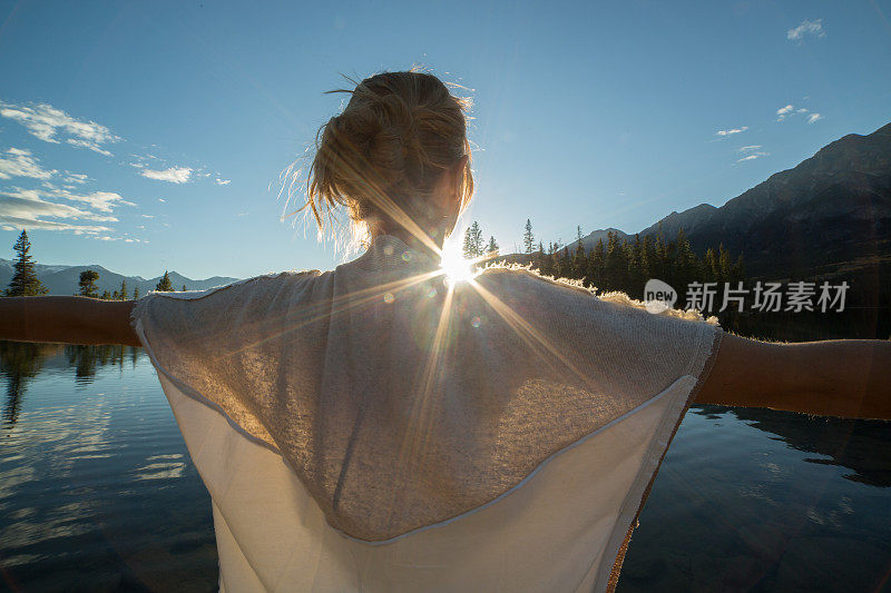 欢呼的女人张开双臂迎接日出